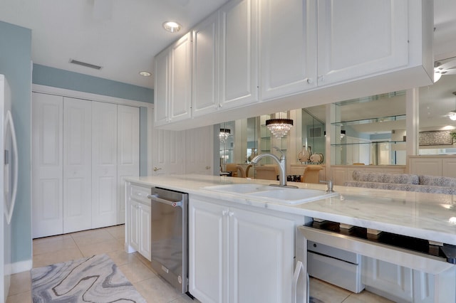 kitchen featuring sink, light tile patterned floors, white refrigerator, dishwasher, and white cabinets