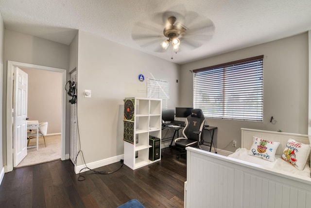 home office featuring dark wood-type flooring, ceiling fan, and a textured ceiling