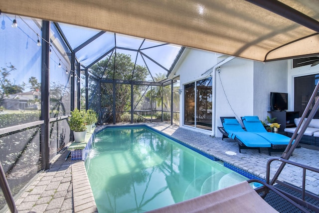 view of pool with a lanai, a patio area, and pool water feature