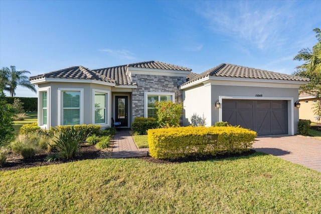 mediterranean / spanish home with a front lawn and a garage