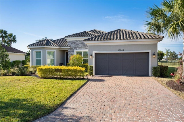 mediterranean / spanish-style house featuring a front yard and a garage