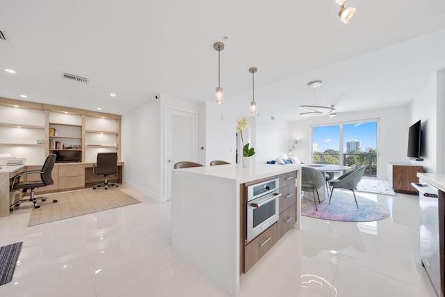 kitchen featuring appliances with stainless steel finishes, a kitchen island, sink, pendant lighting, and white cabinetry