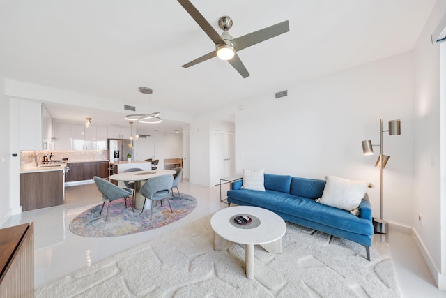 living room with ceiling fan and sink