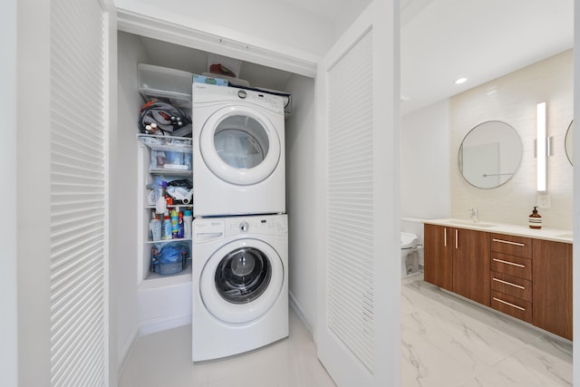 washroom with stacked washer / dryer and sink