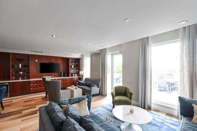 living room featuring beverage cooler and light hardwood / wood-style floors