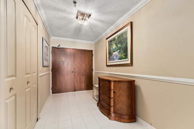 hall with a textured ceiling and ornamental molding