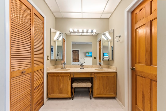 bathroom featuring a paneled ceiling and vanity