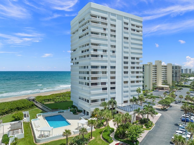 view of property with a water view and a beach view