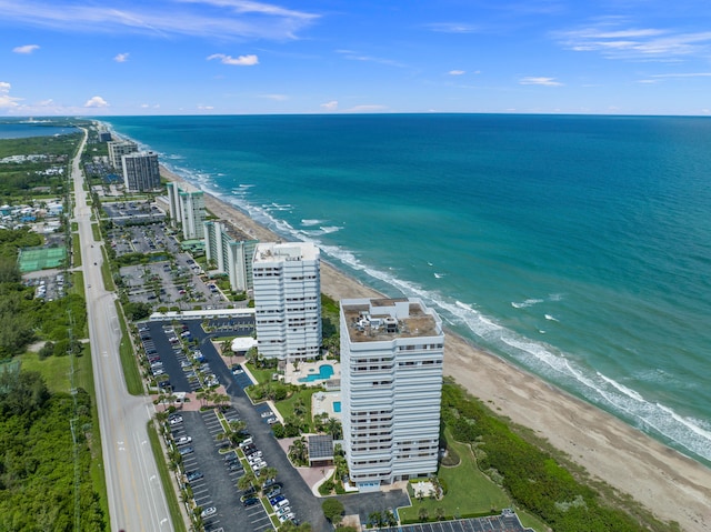 drone / aerial view featuring a water view and a beach view