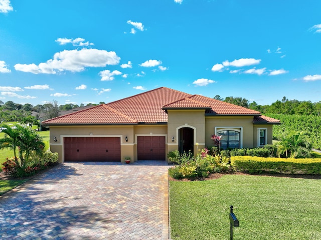 mediterranean / spanish-style house with a front yard and a garage