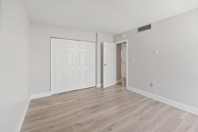 unfurnished bedroom with light hardwood / wood-style floors and a closet