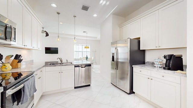 kitchen featuring sink, hanging light fixtures, stainless steel appliances, kitchen peninsula, and white cabinets