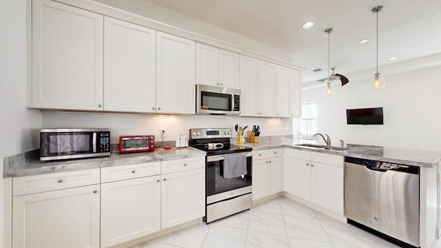 kitchen featuring pendant lighting, sink, white cabinetry, and stainless steel appliances