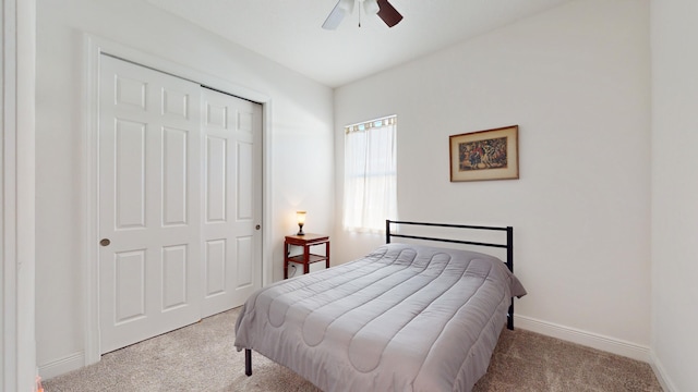 bedroom with ceiling fan, light colored carpet, and a closet