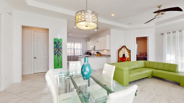 living room featuring a tray ceiling and ceiling fan