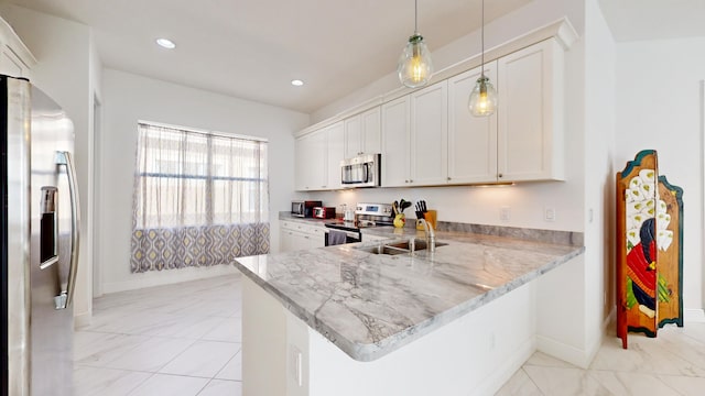 kitchen featuring pendant lighting, white cabinets, sink, appliances with stainless steel finishes, and kitchen peninsula