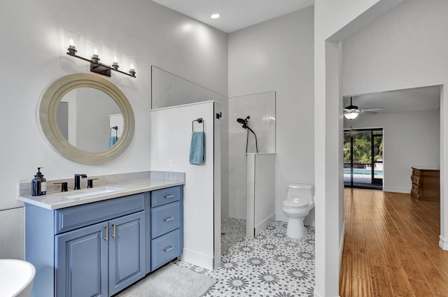 bathroom with vanity, ceiling fan, a shower, wood-type flooring, and toilet