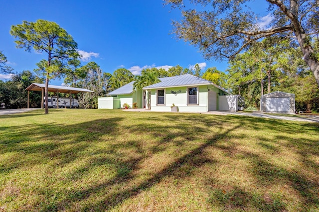 ranch-style house with an outbuilding, a front lawn, and a carport