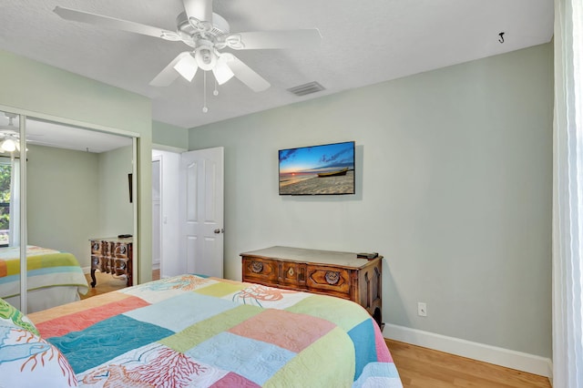 bedroom featuring ceiling fan, a closet, and light hardwood / wood-style floors