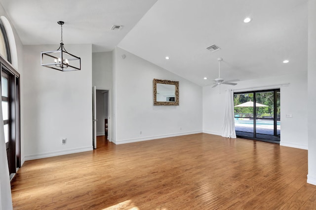 spare room with light hardwood / wood-style flooring, high vaulted ceiling, and ceiling fan with notable chandelier