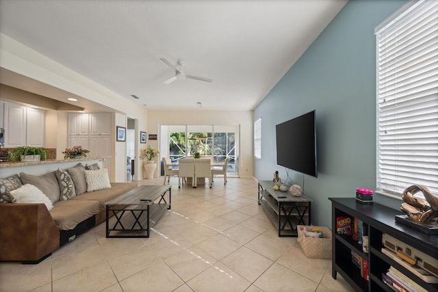 living room featuring ceiling fan, lofted ceiling, and light tile patterned flooring