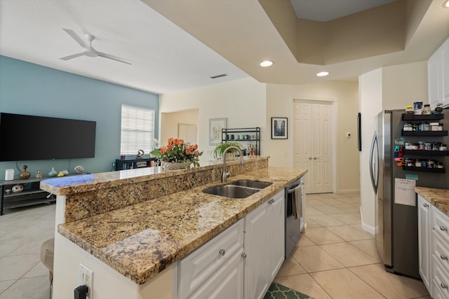 kitchen featuring sink, light tile patterned floors, a center island with sink, white cabinets, and appliances with stainless steel finishes