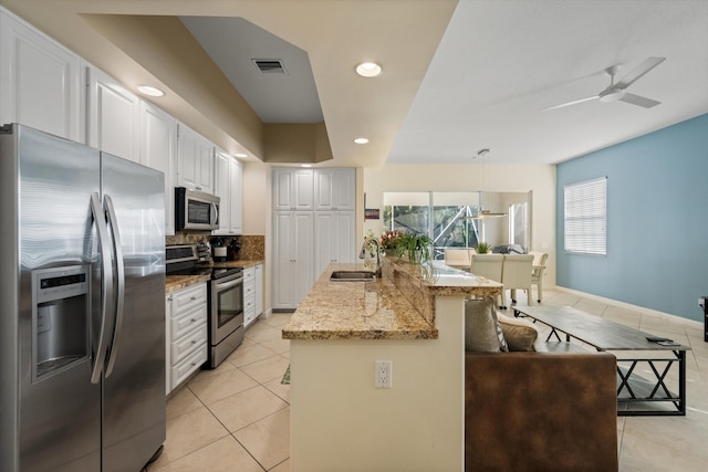 kitchen featuring ceiling fan, sink, hanging light fixtures, stainless steel appliances, and white cabinets