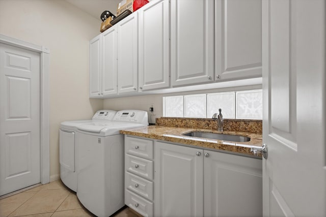 clothes washing area featuring washer and dryer, cabinets, light tile patterned floors, and sink