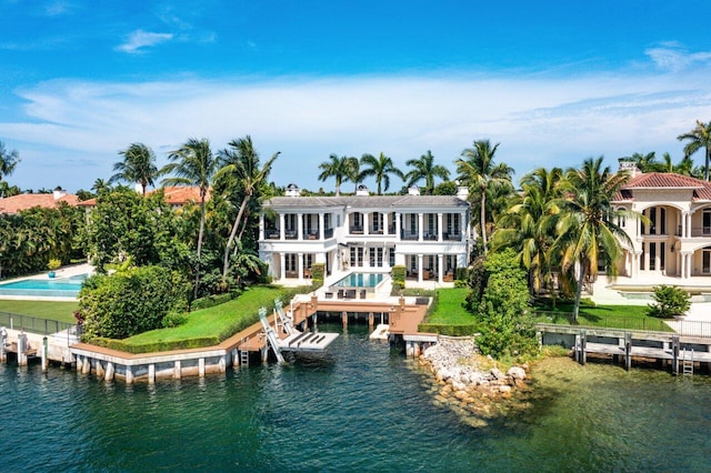 back of property featuring a water view, a yard, and a balcony