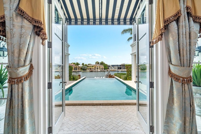 view of swimming pool with a water view and a patio