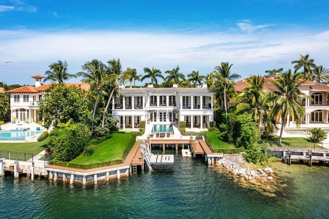 back of property with a water view and a balcony