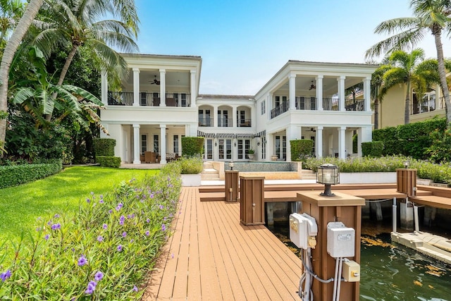 rear view of house featuring ceiling fan, a balcony, a water view, and french doors