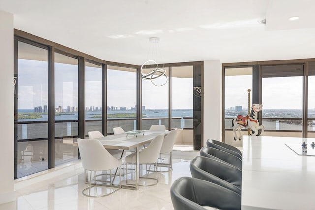 dining space featuring a healthy amount of sunlight, a water view, light tile patterned floors, and floor to ceiling windows