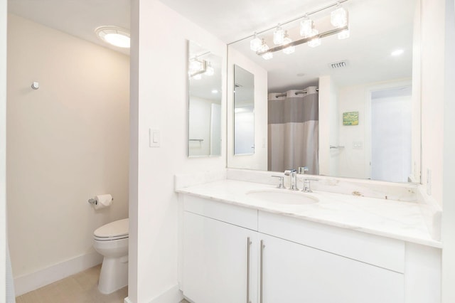 bathroom with tile patterned flooring, vanity, and toilet