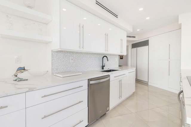 kitchen with light stone countertops, sink, tasteful backsplash, stainless steel dishwasher, and white cabinets