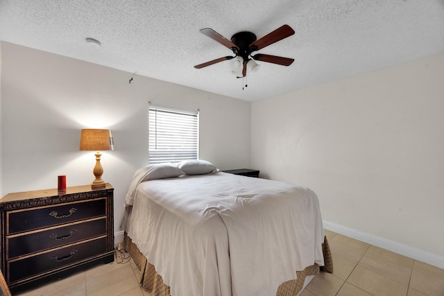 tiled bedroom featuring ceiling fan and a textured ceiling