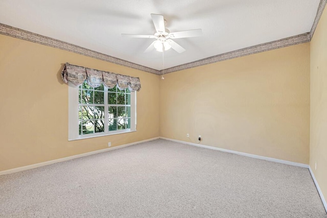 carpeted empty room with ceiling fan and ornamental molding