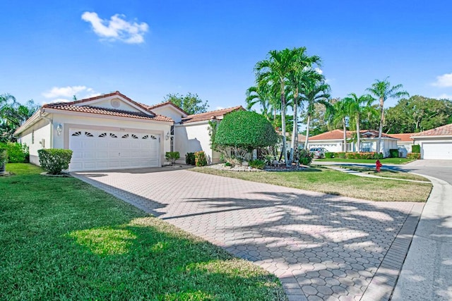 mediterranean / spanish home with a front yard and a garage