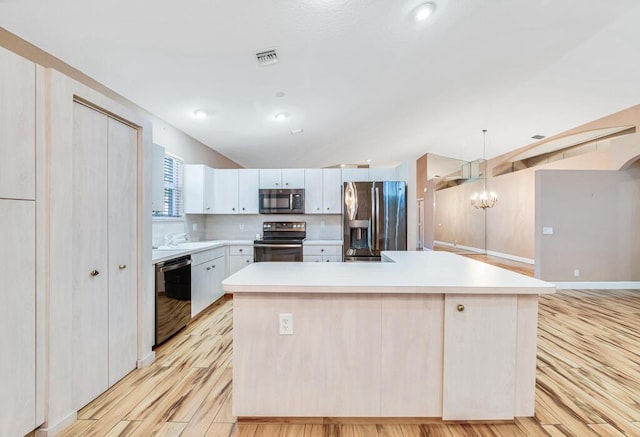 kitchen featuring black appliances, a center island, white cabinetry, and hanging light fixtures