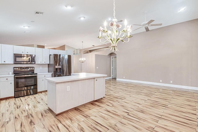 kitchen featuring pendant lighting, white cabinets, stainless steel appliances, and a kitchen island