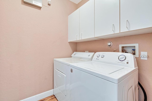 washroom with cabinets, separate washer and dryer, and light hardwood / wood-style floors