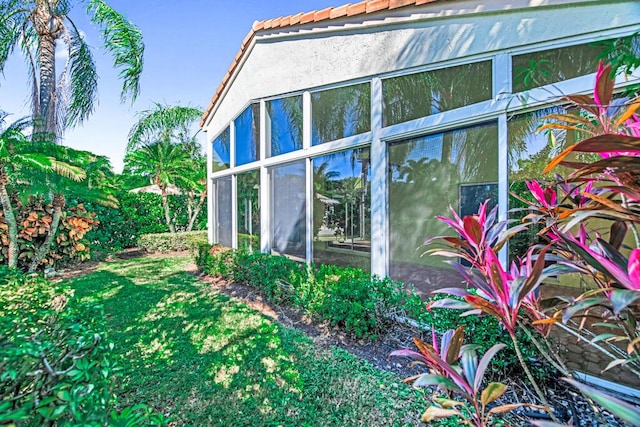 view of property exterior with a sunroom