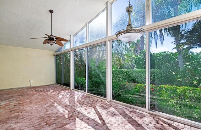 unfurnished sunroom featuring ceiling fan and vaulted ceiling