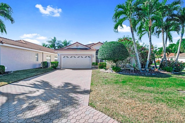 mediterranean / spanish-style house featuring a front yard and a garage