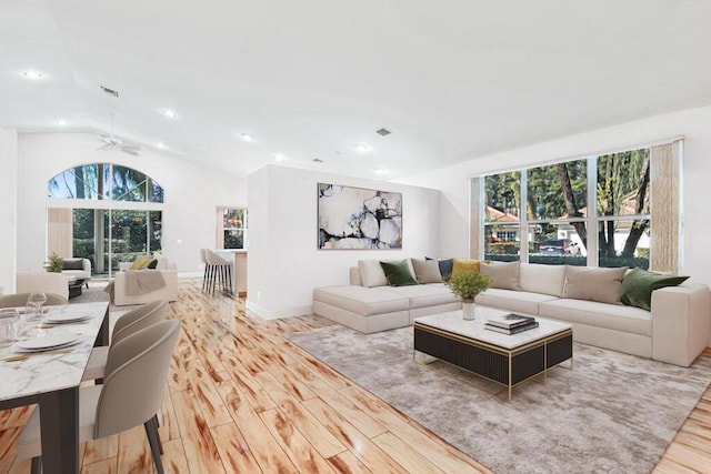 living room with light wood-type flooring, vaulted ceiling, and ceiling fan