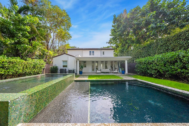 view of swimming pool featuring a patio and central air condition unit