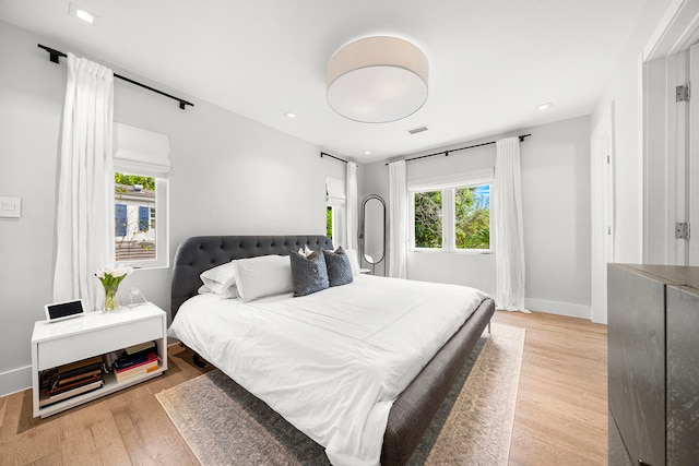 bedroom with light wood-type flooring and multiple windows