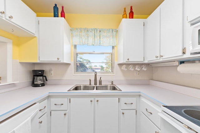 kitchen featuring backsplash, white cabinetry, and sink