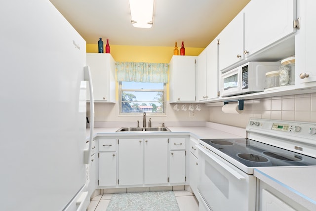 kitchen with white appliances, sink, decorative backsplash, light tile patterned flooring, and white cabinetry