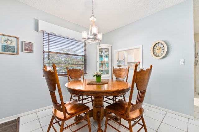 dining room featuring light tile patterned floors, a textured ceiling, and an inviting chandelier